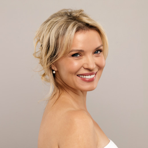 woman-smiling-and-looking-over-her-shoulder-with-radiant-skin