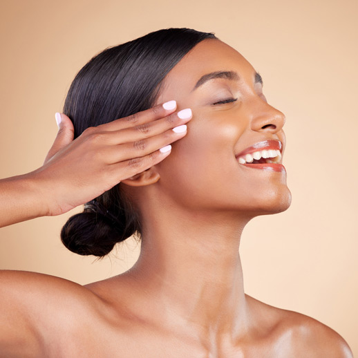 woman-smiling,-gently-touching-the-side-of-her-face