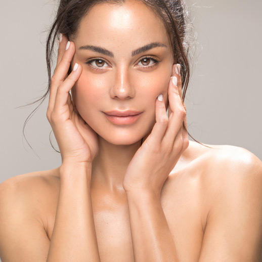 woman-with-smooth-glowing-skin-touching-her-face