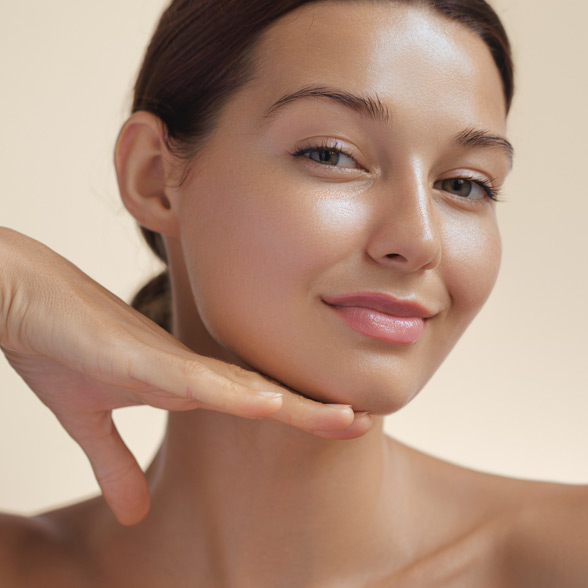 woman-with-smooth-radiant-skin-smiling-and-touching-her-face