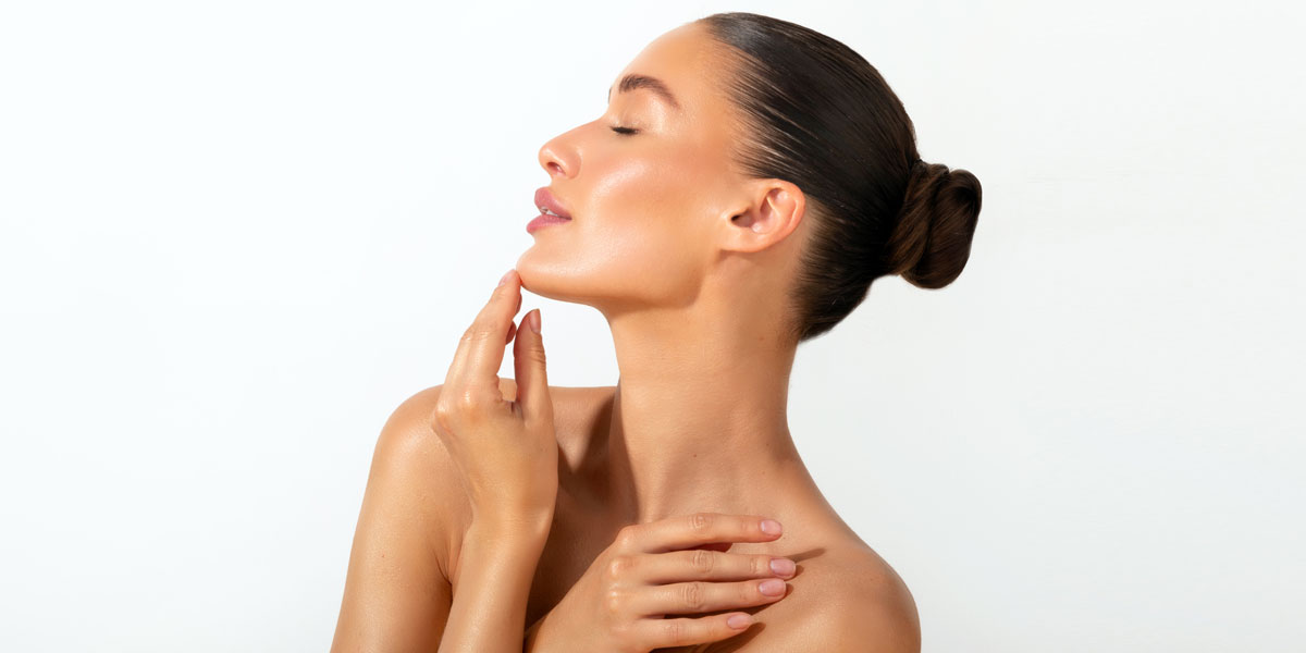 Profile view of woman touching chin with smooth radiant skin