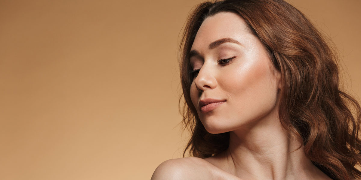 Woman looking sideways with clear luminous skin and soft glow