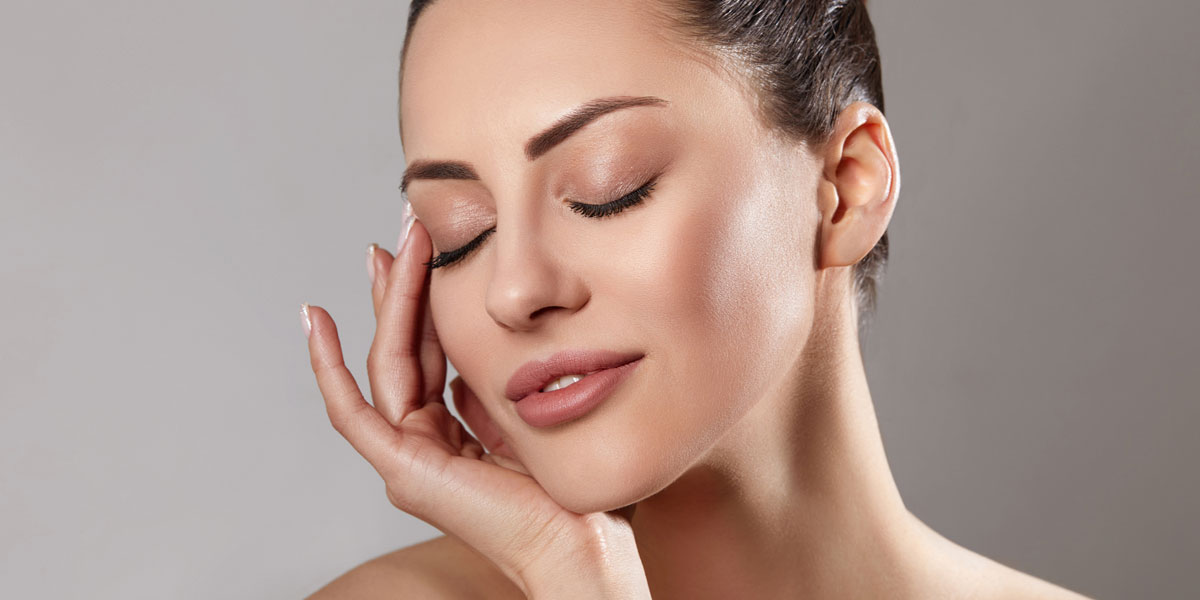Woman resting hand on cheek with smooth radiant complexion