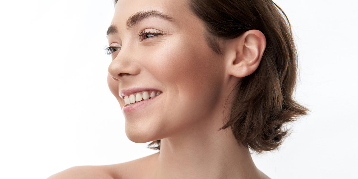 Woman smiling in profile with smooth glowing complexion