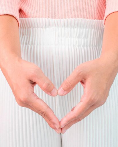 woman-forming-a-heart-shape-with-her-hands-over-her-lower-abdomen