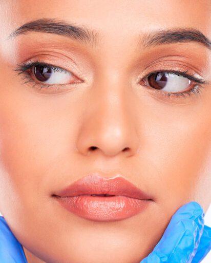 woman-receiving-a-cosmetic-injection-near-her-eye-from-a-gloved-provider