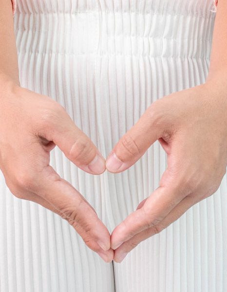 Hands forming heart shape over lower abdomen