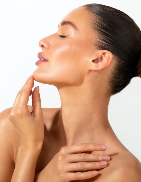 Profile view of woman touching chin with smooth radiant skin