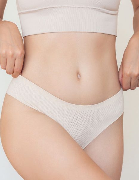 Woman adjusting waistband of underwear around hips