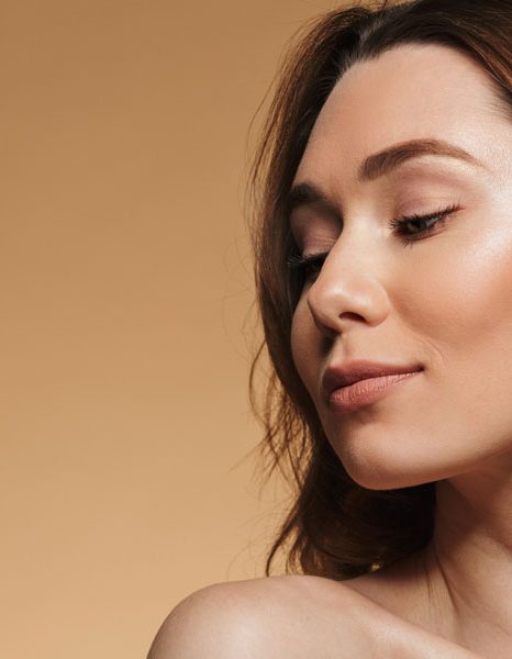 Woman looking sideways with clear luminous skin and soft glow