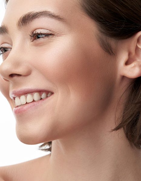 Woman smiling in profile with smooth glowing complexion