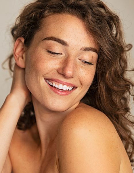 Woman smiling with natural glow and clear healthy skin