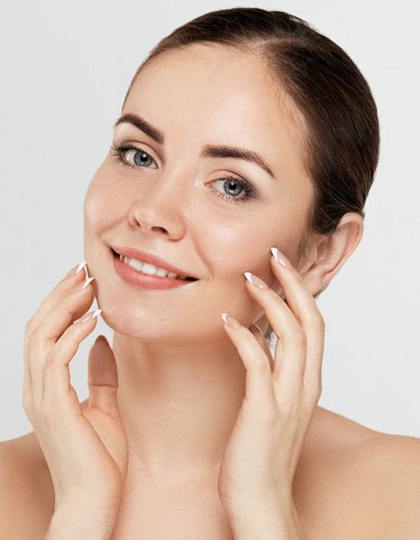 Woman touching face with soft healthy glowing skin