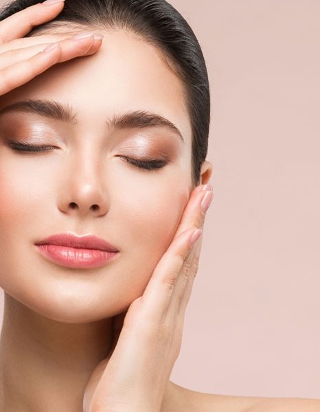 Woman-with-eyes-closed-gently-holding-face-showing-smooth-glowing-skin